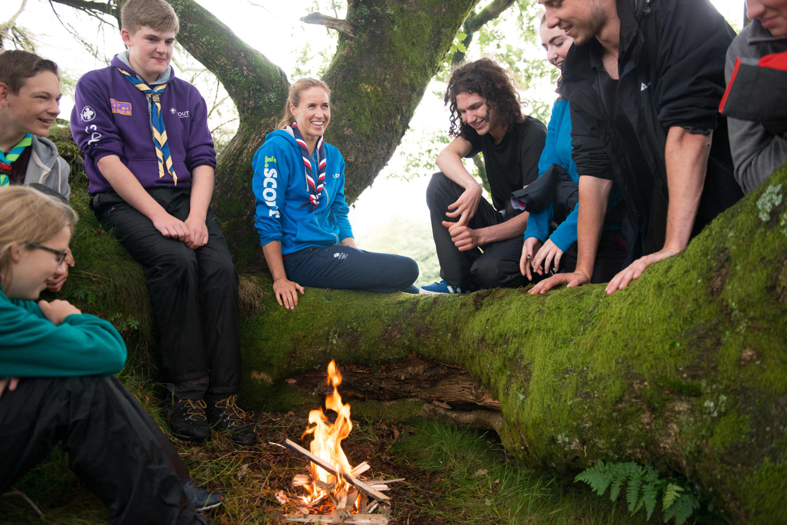 Scouts relaxing around a tree